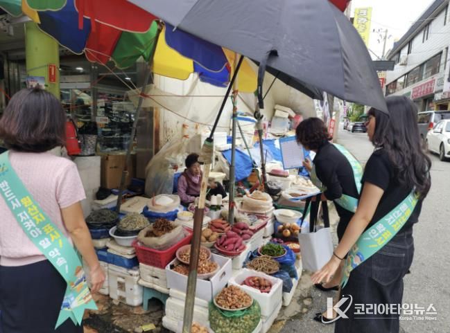 온양온천 전통시장에서 상인에게 농산물 원산지 표시제를 홍보하고 있다.