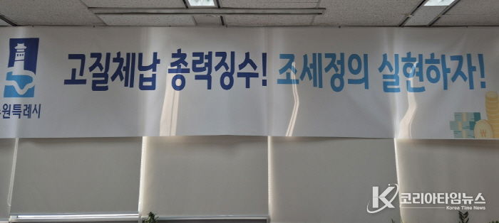 ‘고질체납 총력 징수! 조세정의 실현하자!’ 수원시 징수과 사무실에 걸려 있는 현수막.