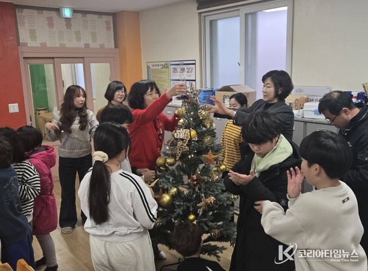 금산다락원 직원들이 사랑호크마지역아동센터 아동들과 크리스마스트리를 만들고 있다.
