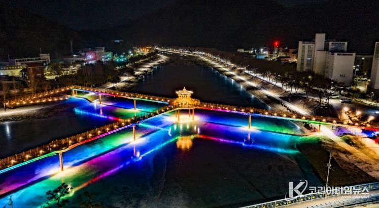 한파로 얼어붙은 괴산군 성황천과 동진천 위로 두 하천을 잇는 에코브릿지의 다채로운 색감의 경관조명이 얼음에 반영돼 겨울밤 수변의 이색적인 풍경을 연출하고 있다.