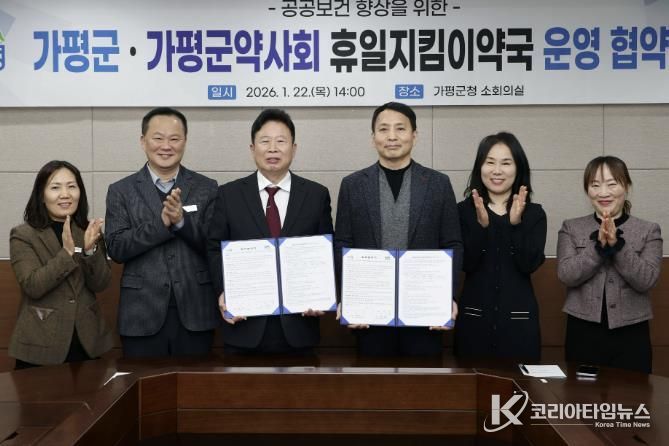 서태원 가평군수(사진 왼쪽에서 세번째)와 안병현 가평군약사회 회장(〃 네번째) 등이 22일 휴일지킴이약국 운영 협약식 후 협약서를 보이며 기념촬영을 하고 있다.