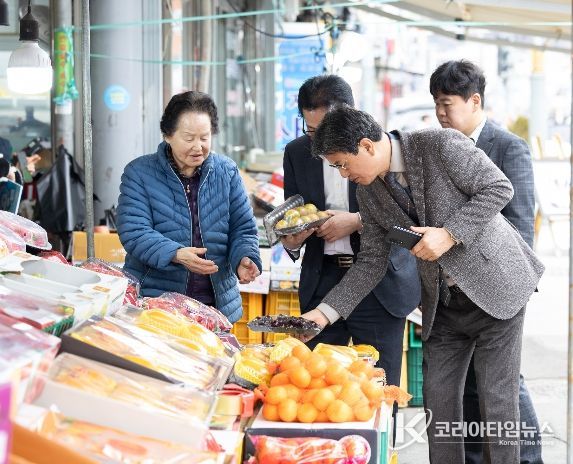 김돈곤 청양군수가 청양전통시장에서 과일을 고르며 농어촌 기본소득을 사용하는 모습